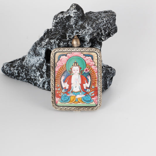 Front view of a Four-Armed Avalokiteshvara mini Thangka pendant, fully hand-painted with mineral pigments and framed in a pure silver gawu-style pendant case with traditional Tibetan decorative patterns.