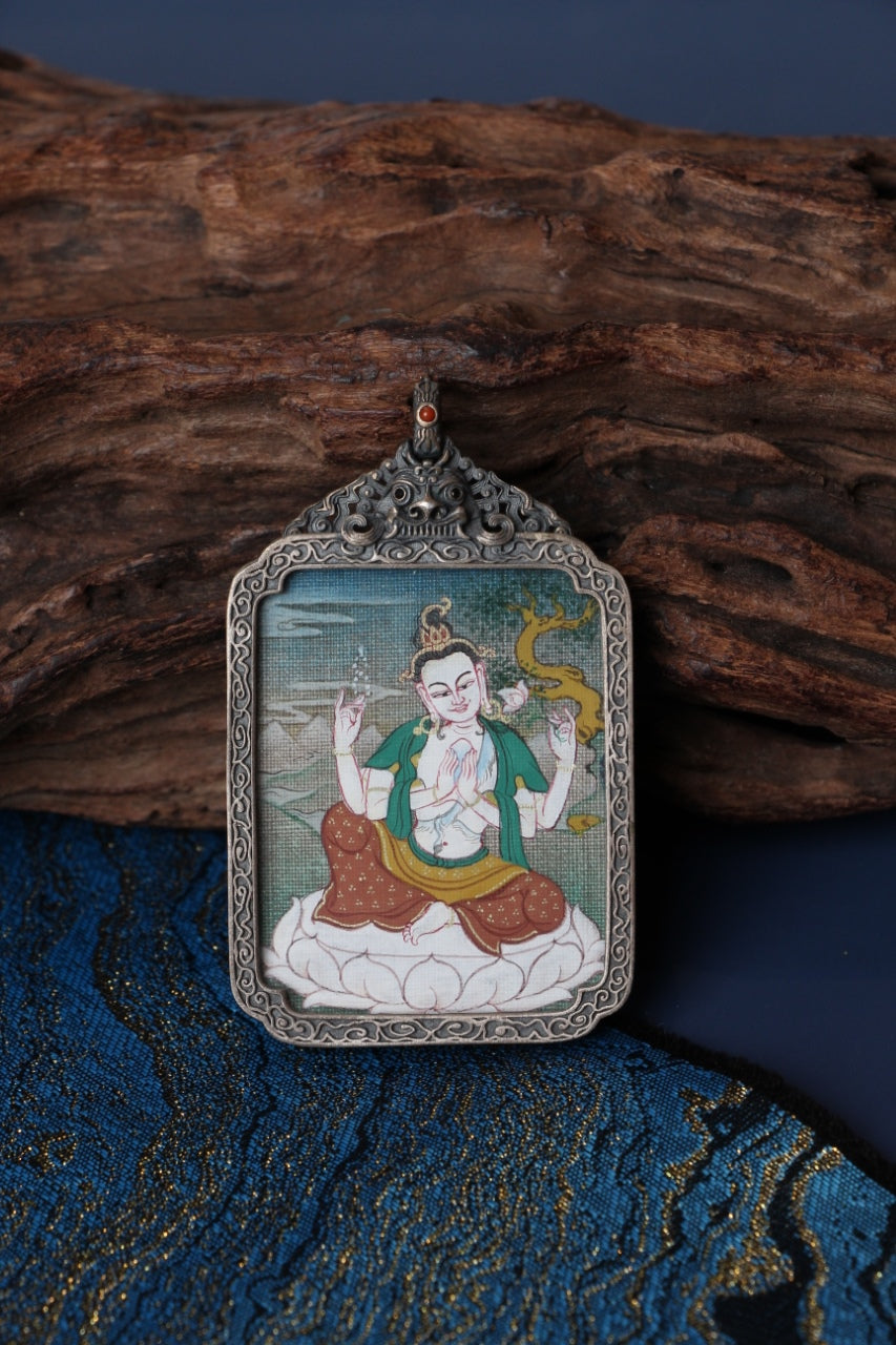 Close-up detail of Four-Armed Avalokiteshvara mini thangka pendant, showing traditional Tibetan hand-painted mineral pigment artwork inside a vintage silver case