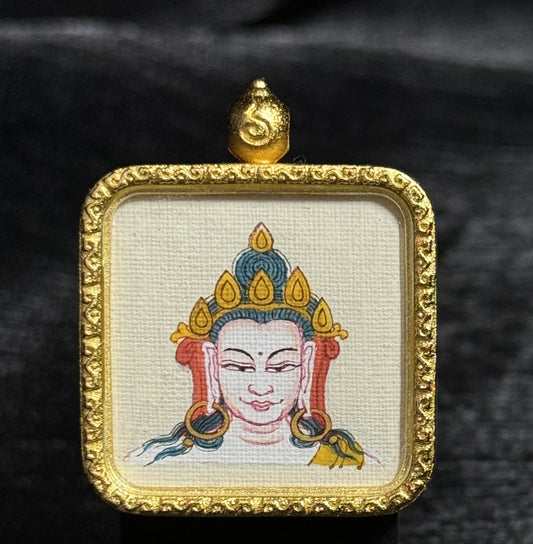 Hand-painted Four-Armed Avalokiteshvara (Chenrezig) miniature thangka pendant, featuring a compassionate deity face with a jeweled crown and large circular earrings, painted with natural mineral pigments on canvas and set inside an ornate square gold frame with traditional Tibetan decorative edges.