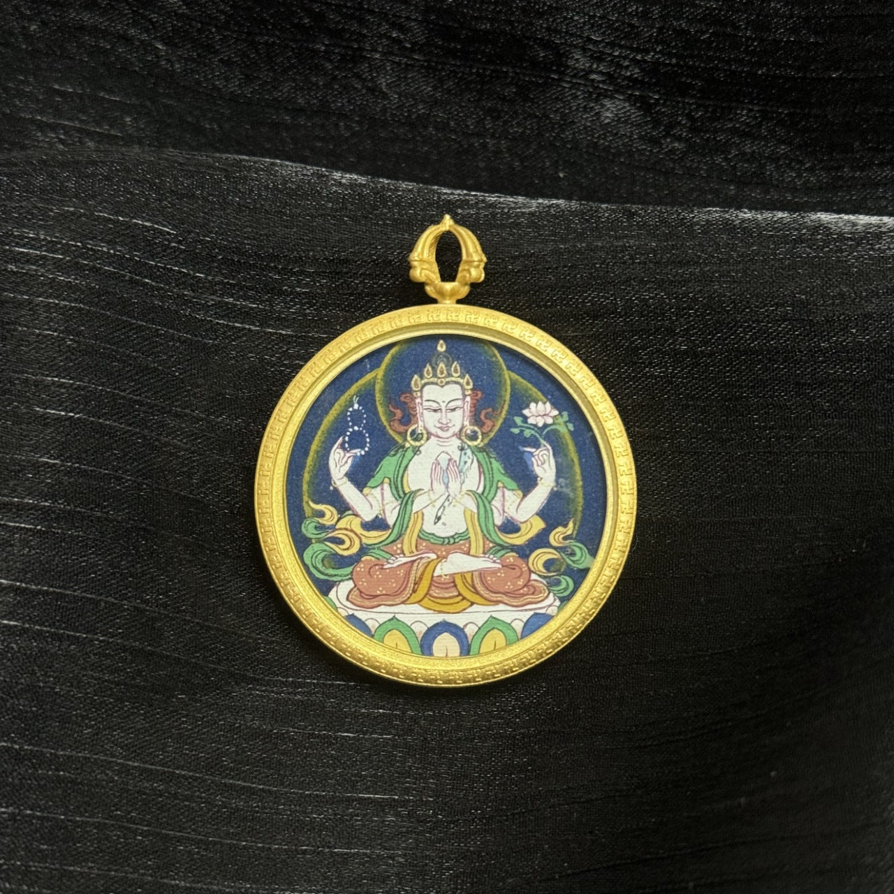 Hand-painted Four-Armed Avalokiteshvara round mini thangka pendant from Tibet, crafted with natural mineral pigments and set in a vintage brass case