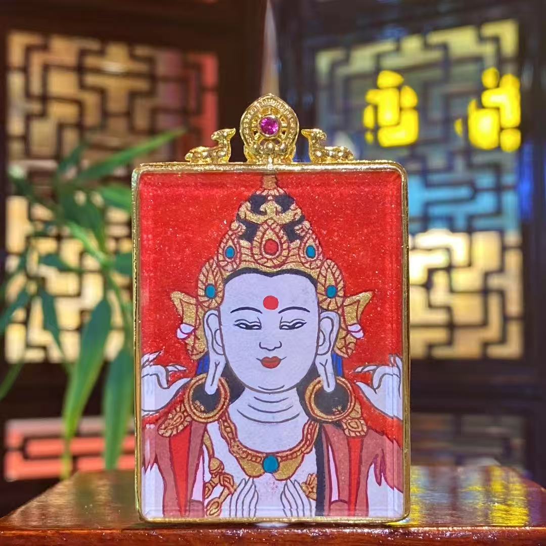 Hand-painted Four-Armed Avalokiteshvara thangka pendant in a small gilded copper Ghau box, front view