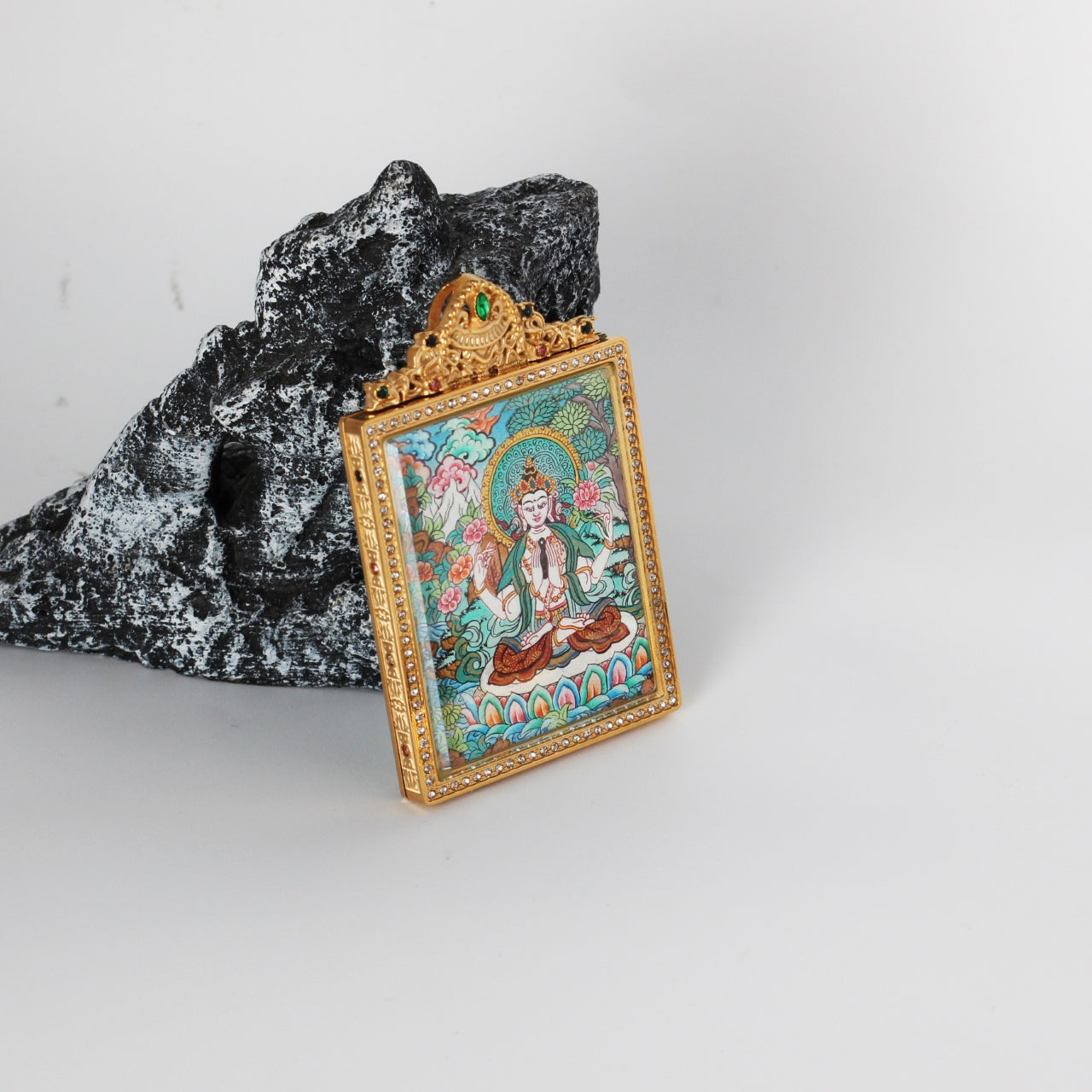 Four-Armed Avalokiteshvara mini thangka pendant from Nepal, featuring a jeweled metal frame and compassionate Buddhist imagery.