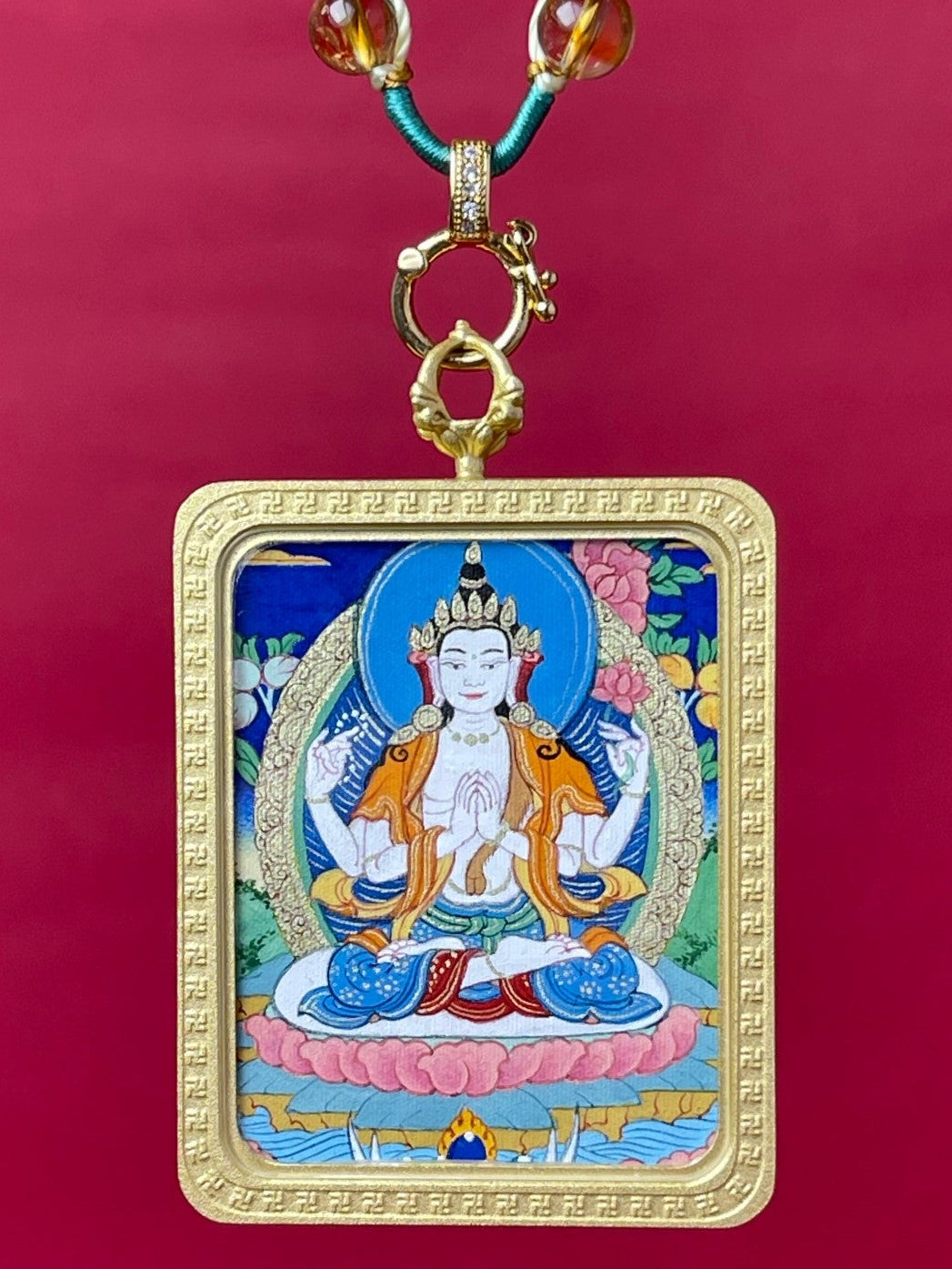 Hand-painted Four-Armed Avalokiteshvara Tibetan Thangka pendant with mineral pigments, copper frame, front view