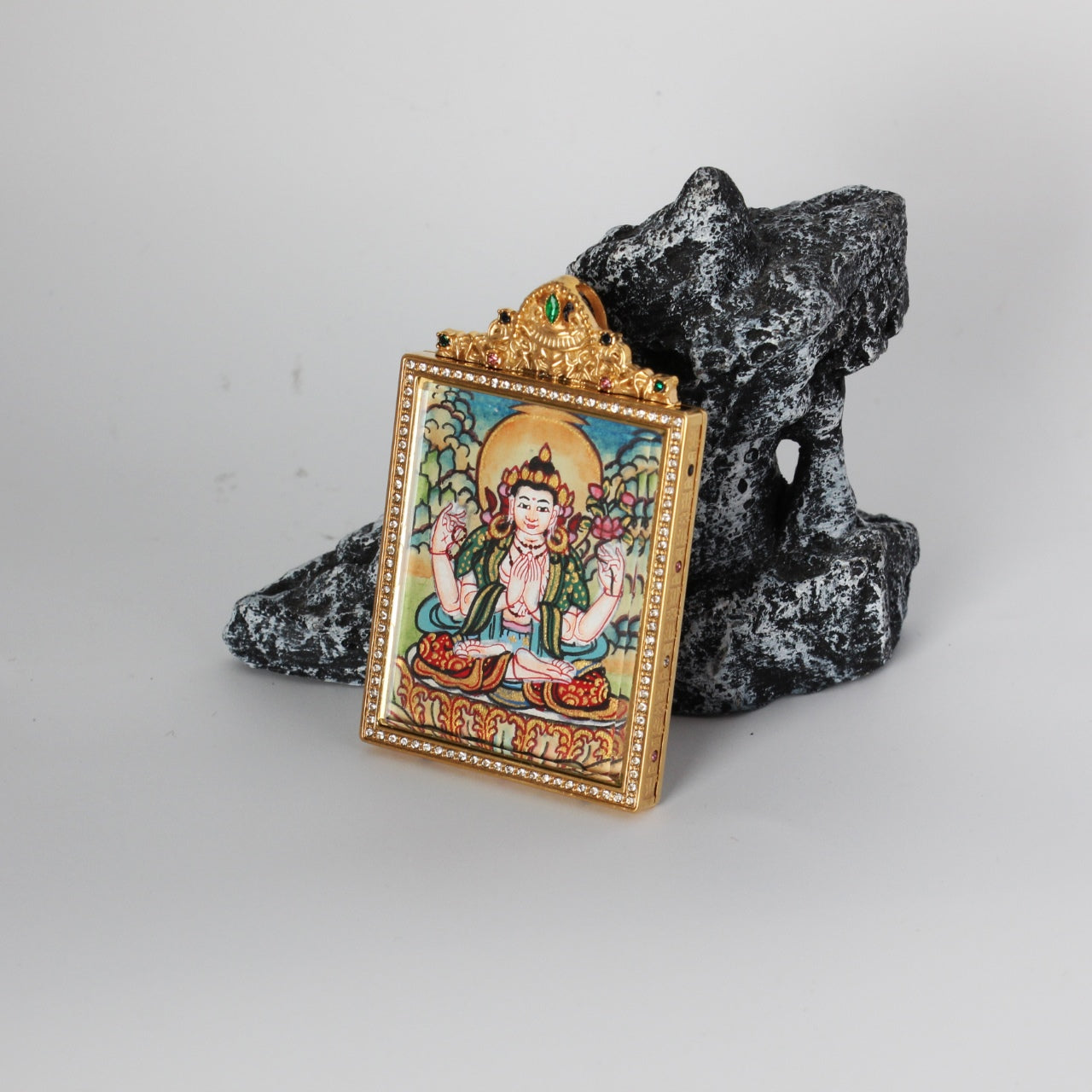 Angled view of Four-Armed Avalokiteshvara (Chenrezig) mini thangka pendant with jeweled double-sided titanium steel case from Nepal pastel series, 4×5.