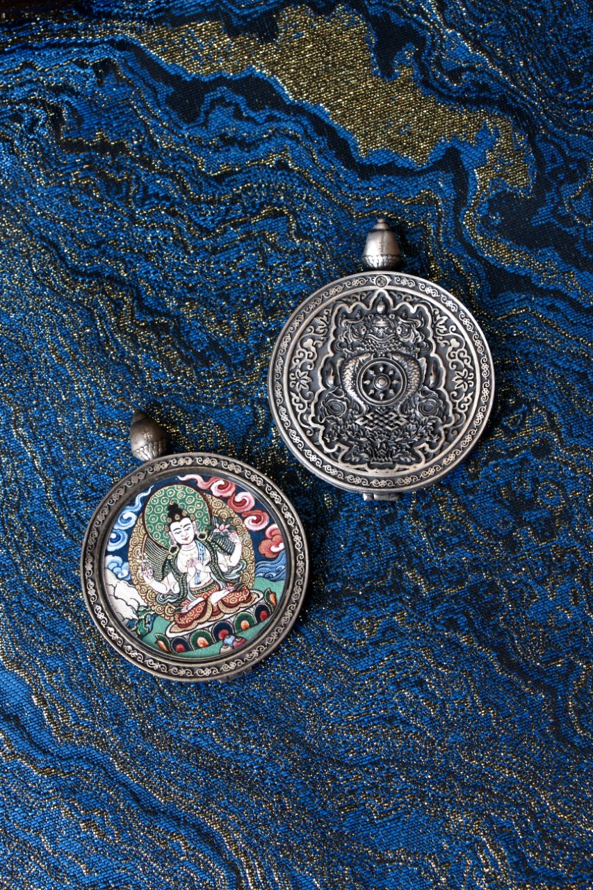 Double-sided Four-Armed Avalokiteshvara thangka pendant showing hand-painted deity on the front and engraved protective design on the back, crafted in traditional Rebgong style with 925 silver casing