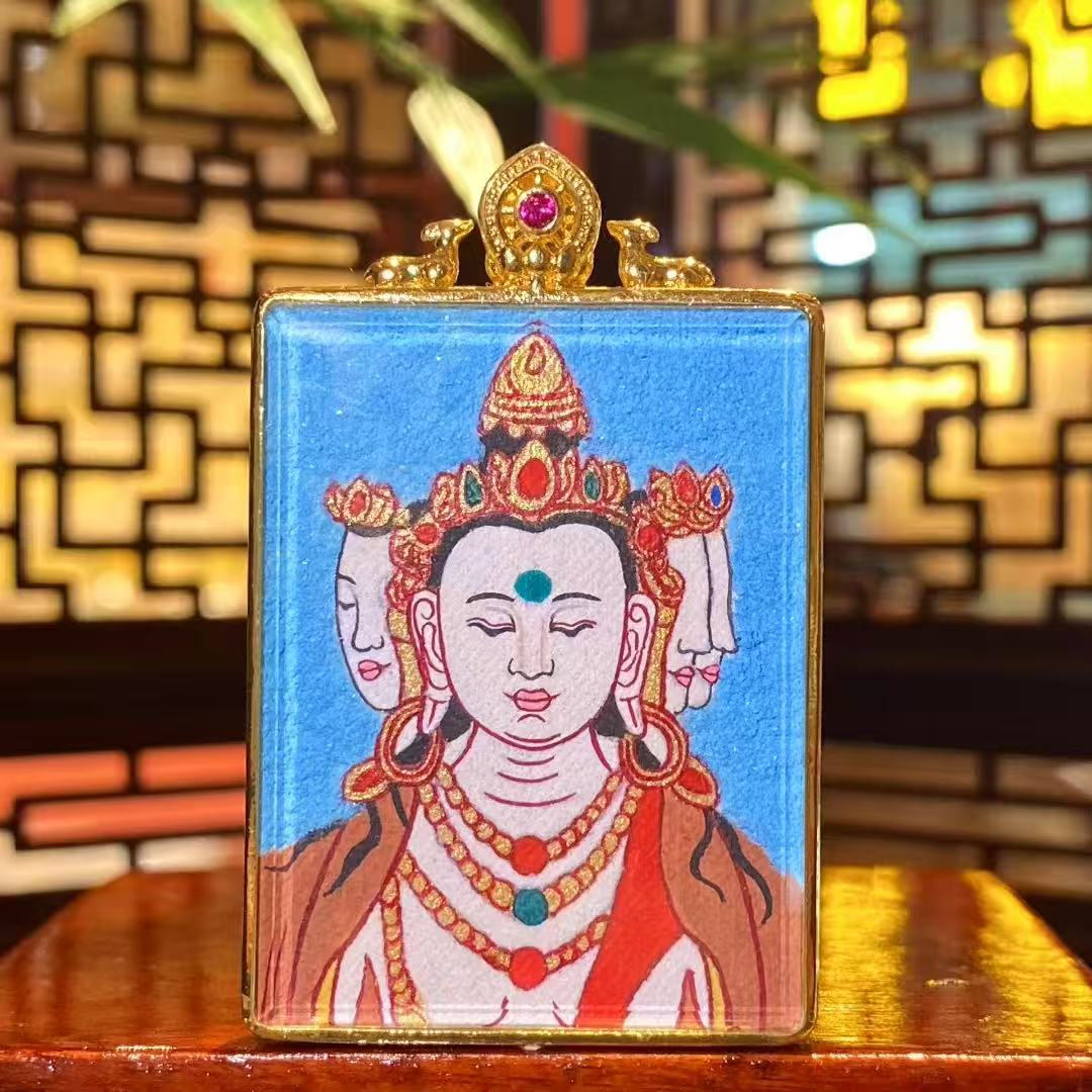 Front view of a hand-painted Vairocana Buddha mini thangka pendant in a gold-plated copper Gawu box, single-sided painting, 33×43mm
