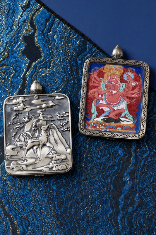 Front view of Ganesha mini thangka pendant, hand-painted with mineral pigments in Tibetan tradition, set in a Dunhuang Nine-Colored Deer solid silver gawu case