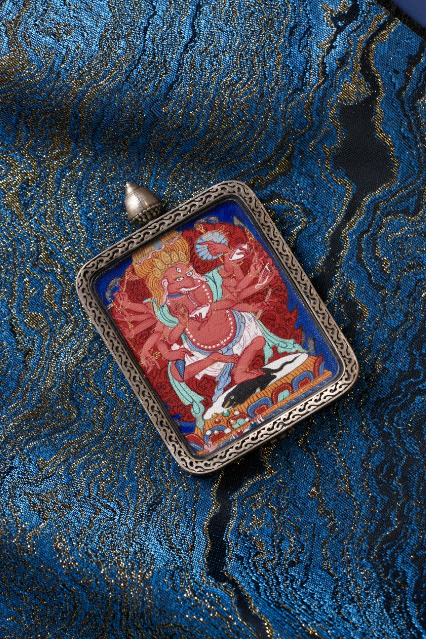 Ganesha mini thangka pendant displayed alongside its solid silver gawu case, highlighting traditional Tibetan metalwork and pendant structure