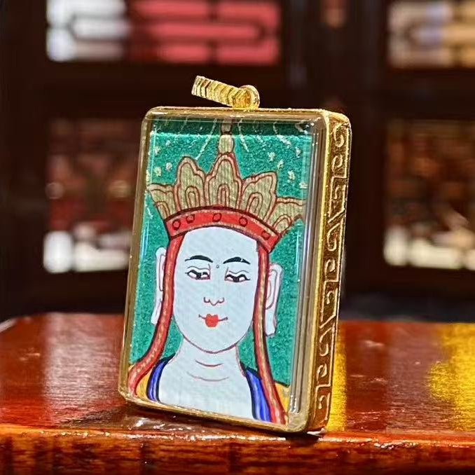 Side view of an 18K gold Gau box Thangka pendant showing the hollow double-sided structure and sapphire crystal glass on both sides