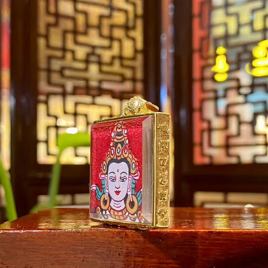 Side view of Four-Armed Avalokiteshvara mini thangka pendant showing the gilded copper Ghau box craftsmanship