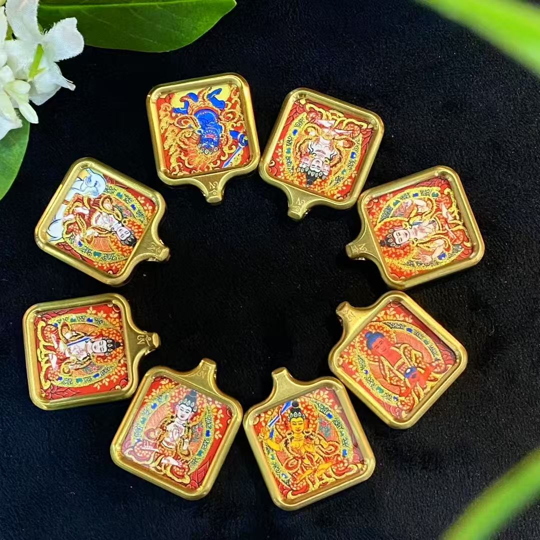 Close-up of gold line detailing on hand-painted miniature Tibetan thangka pendant for wholesale production