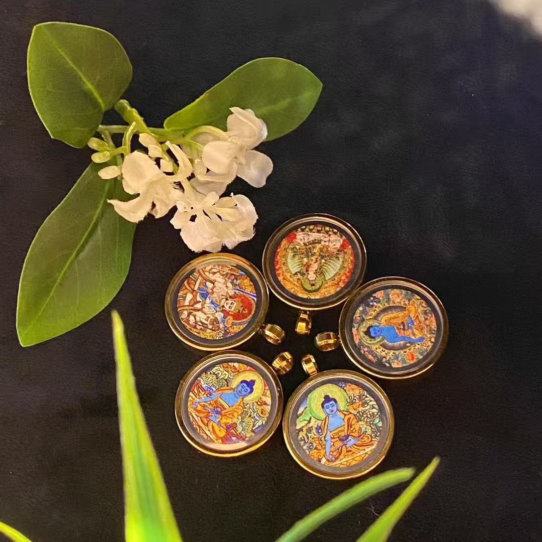 Close-up of gold line detailing on hand-painted miniature Tibetan thangka pendant for wholesale production