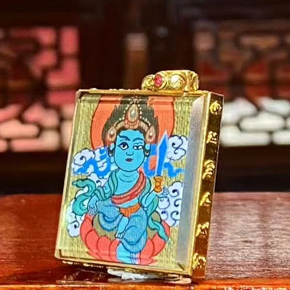 Side view of a double-sided Gau Thangka pendant showing the refined 18K gold frame and detailed Regong hand-painted craftsmanship