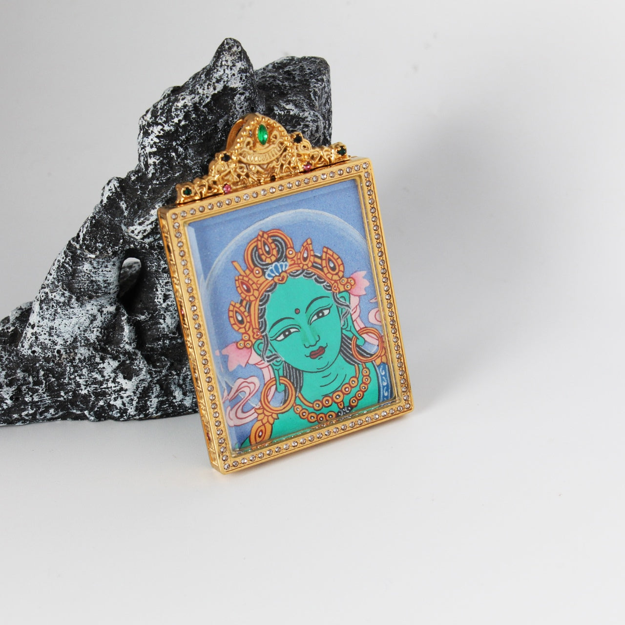 Close view of Green Tara Buddha head painting highlighting fine facial line work, turquoise-green complexion, gold crown motifs, and the crystal-trimmed titanium steel frame
