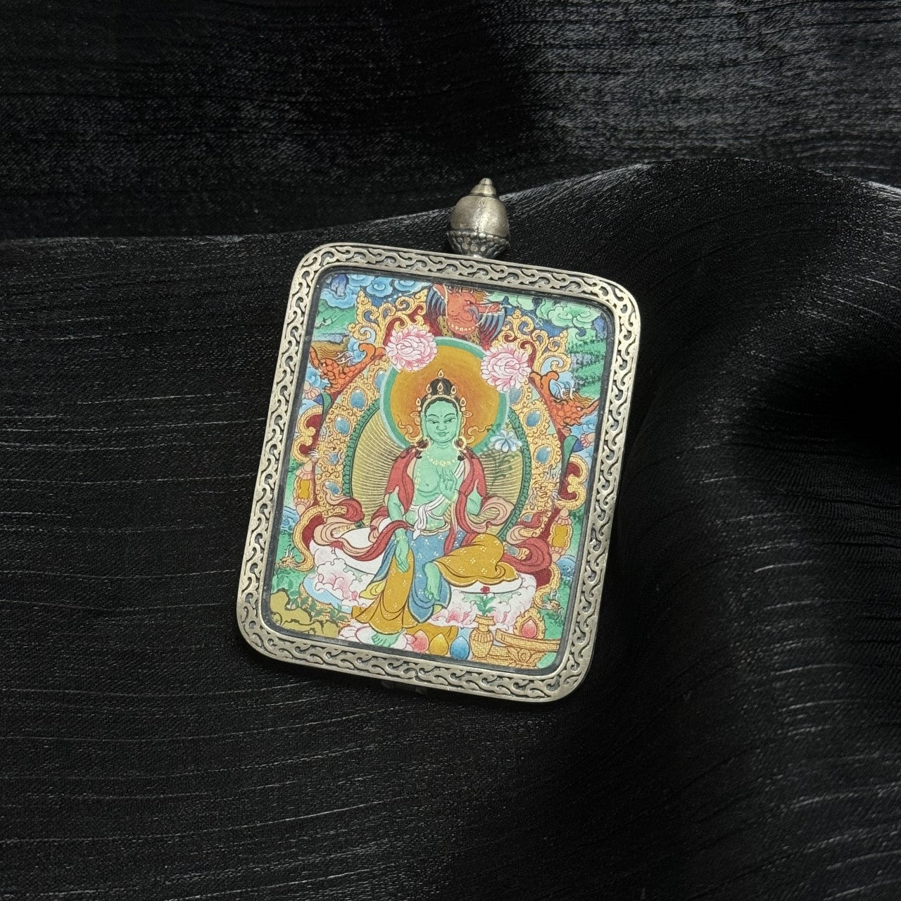 Artistic view of a Green Tara Buddhist thangka pendant from Tibet, painted in Mentang style, ideal for spiritual practice, protection, and collection.