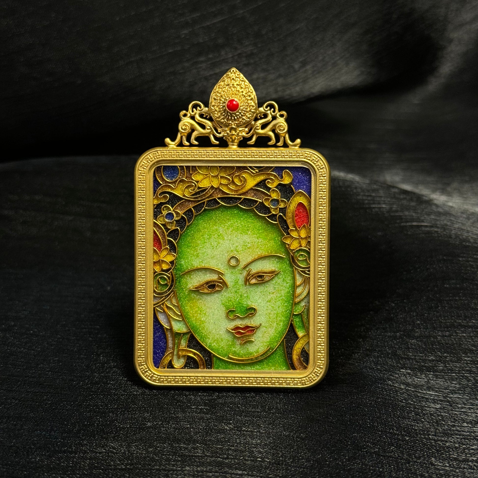 Front view of Green Tara mini thangka pendant featuring cloisonné enamel artwork with green face detail, gold-plated copper frame, and ornamental top design.