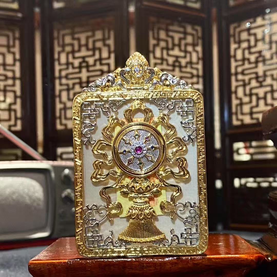 Back view of a Green Tara gilded copper Ghau box pendant featuring a Turning of Fortune symbolic design