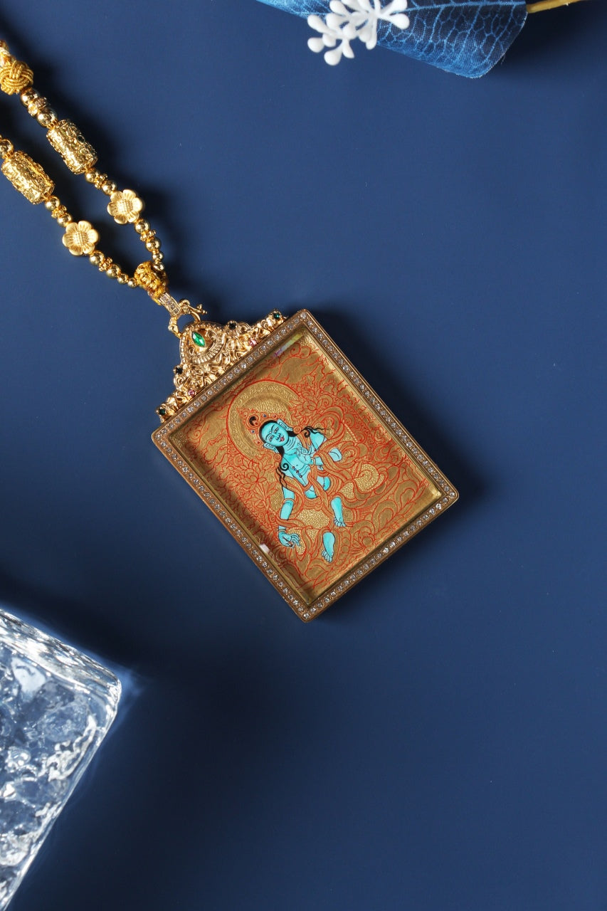 Angled view of Green Tara gold-ground mini thangka pendant, showing square frame construction, crystal border detailing, and ornate pendant bail with green gemstone