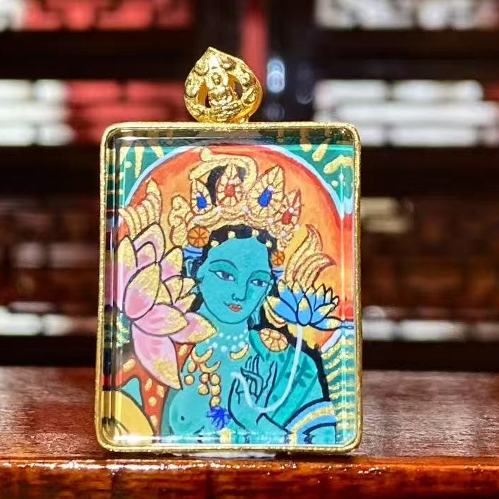 Front view of a double-sided hand-painted Gau Thangka pendant featuring Green Tara, crafted in an 18K gold case with sapphire crystal protection