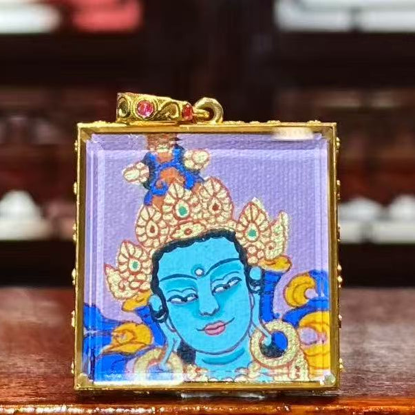 Front view of a double-sided hand-painted Gau Thangka pendant featuring Green Tara, crafted in an 18K gold case with sapphire crystal glass