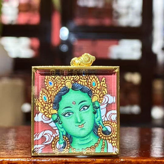 Front view of a hand-painted Green Tara Gau Thangka pendant featuring a serene Green Tara portrait in an 18K gold case with sapphire crystal glass