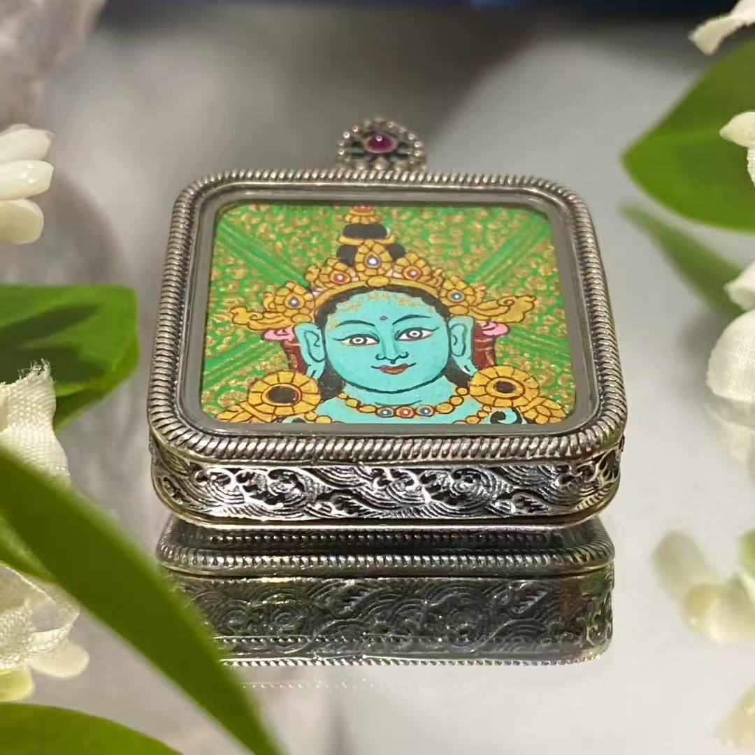 Front view of a hand-painted Green Tara thangka pendant in an S925 silver Ghau box, 29 mm diameter