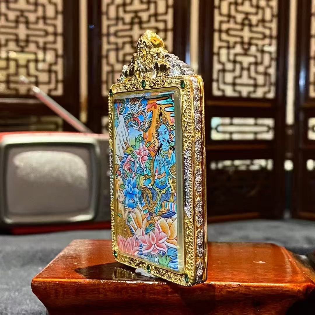Side view of a hand-painted Green Tara thangka pendant in a gilded copper Ghau box, size 55 × 45 mm
