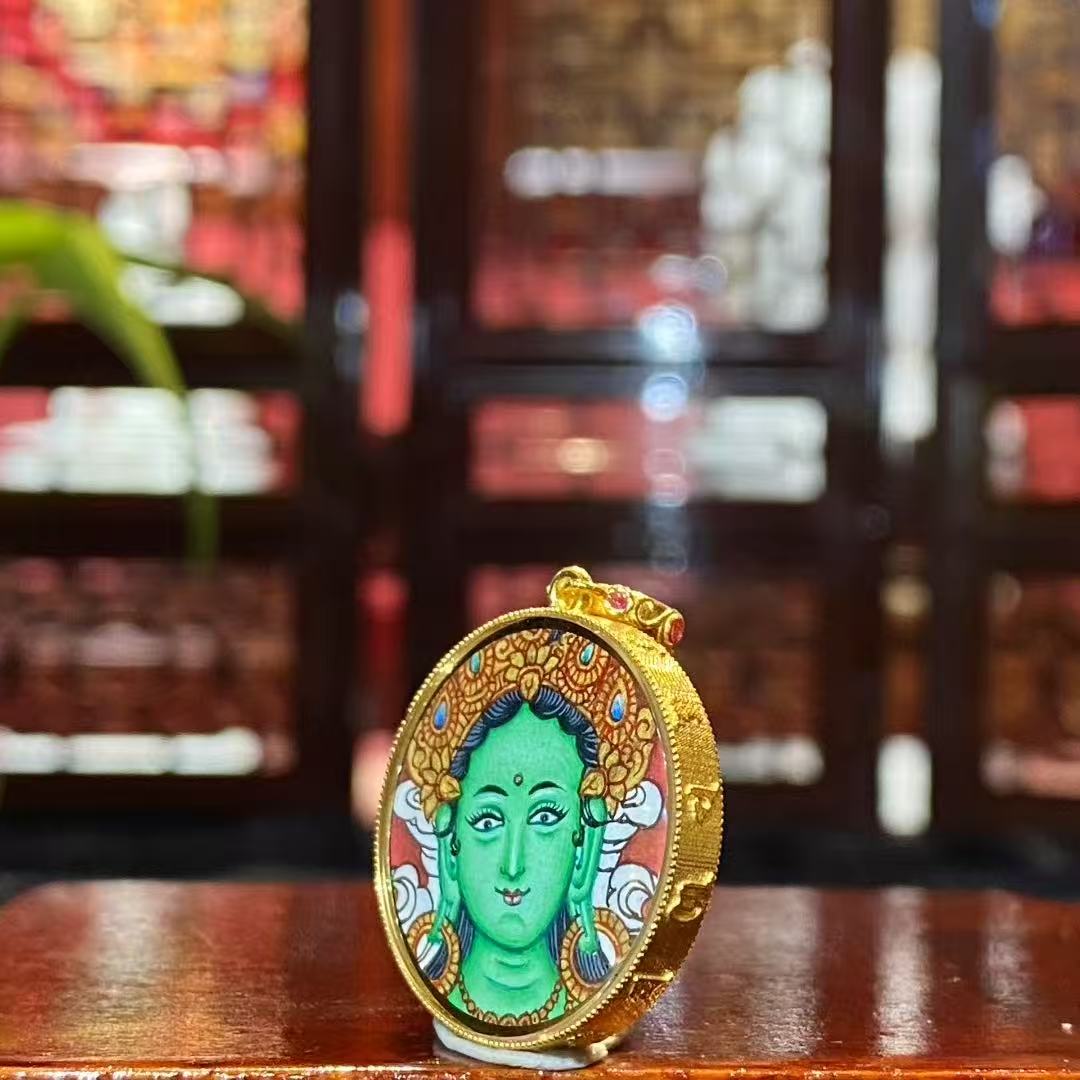 Side view of a round double-sided Tibetan Thangka pendant set in an 18K gold Gau box with sapphire crystal, showing balanced circular form and craftsmanship.
