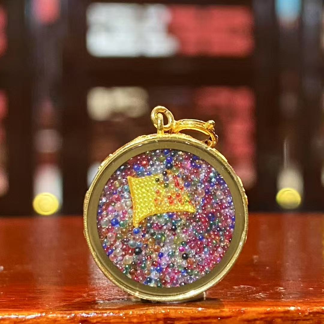 Back view of a mini Green Tara Thangka pendant showing the smooth metal back of the solid 18K gold Gau box designed for sacred enshrinement.
