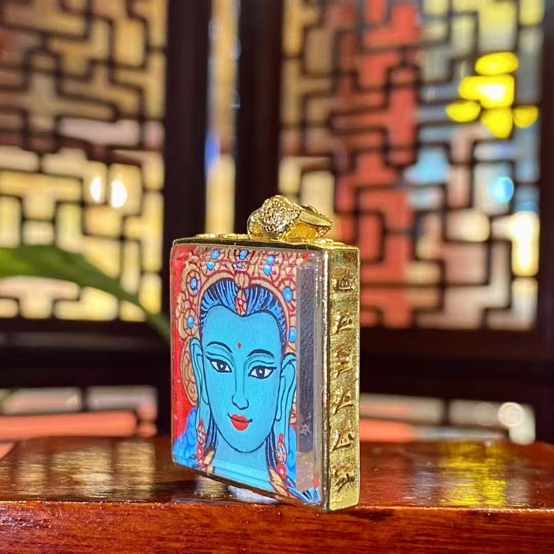 Side view of a Green Tara mini thangka pendant showing the copper Ghau box craftsmanship