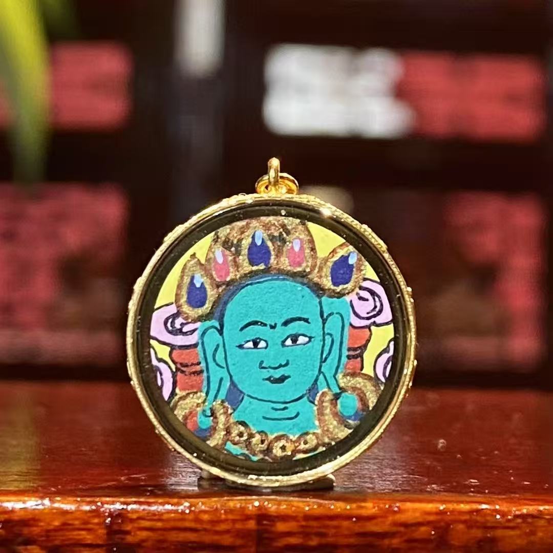 Front view of a mini Green Tara Thangka pendant, hand-painted with 18K gold in Rebgong tradition, depicting Green Tara in a refined and delicate form.
