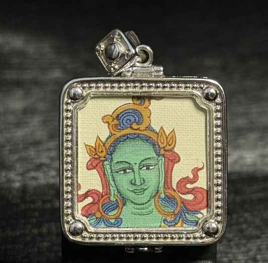 Front view of Green Tara mini thangka pendant featuring hand-painted Tibetan Buddhist art with natural mineral pigments in a silver gawu pendant frame
