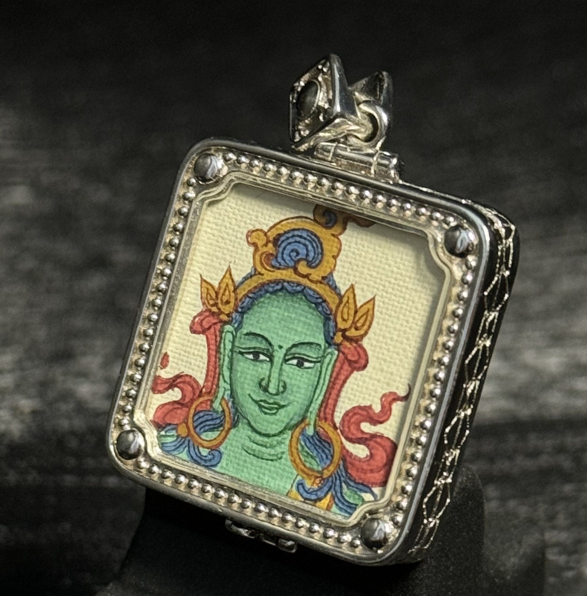 Top angled view of Green Tara miniature thangka pendant showing Tibetan gawu style pendant case and sacred thangka painting