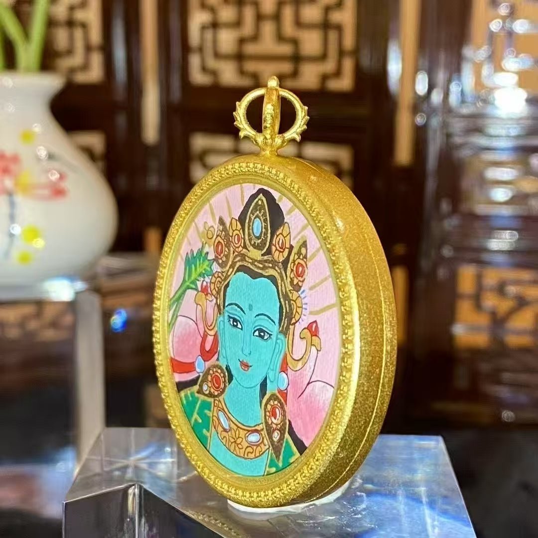 Side detail of a Green Tara thangka pendant showing the round copper Ghau box and decorative frame