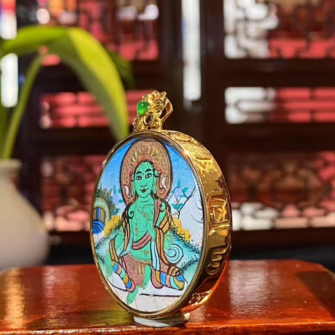 Side view of a round Tibetan Thangka pendant set in an 18K gold Gau box with sapphire crystal cover, showing the thickness and craftsmanship of the pendant.
