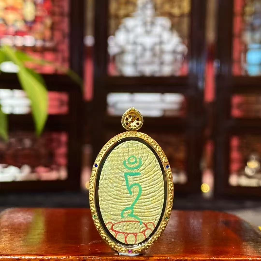 Back view of a double-sided Thangka pendant featuring the seed syllable of Green Tara’s heart mantra, fully hand-painted with 18K gold in Rebgong tradition.

