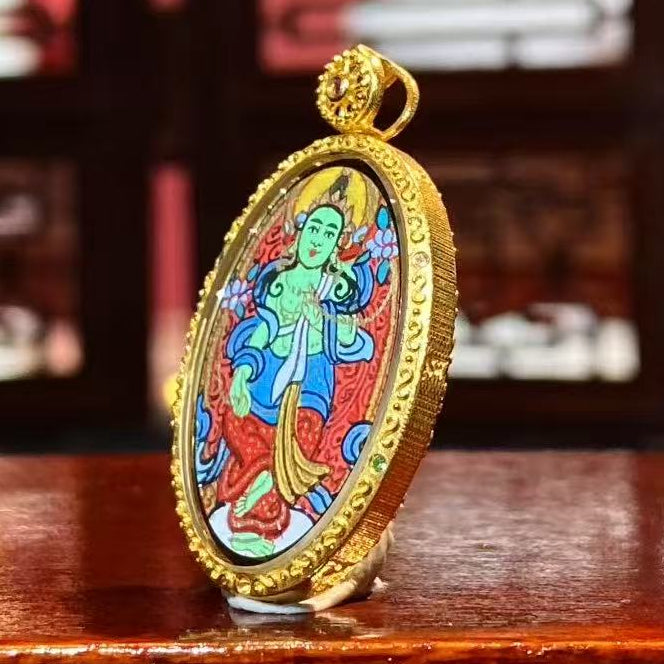 Side view of a double-sided Tibetan Thangka pendant set in an 18K gold Gau box with sapphire crystal, showing compact proportions and fine craftsmanship.
