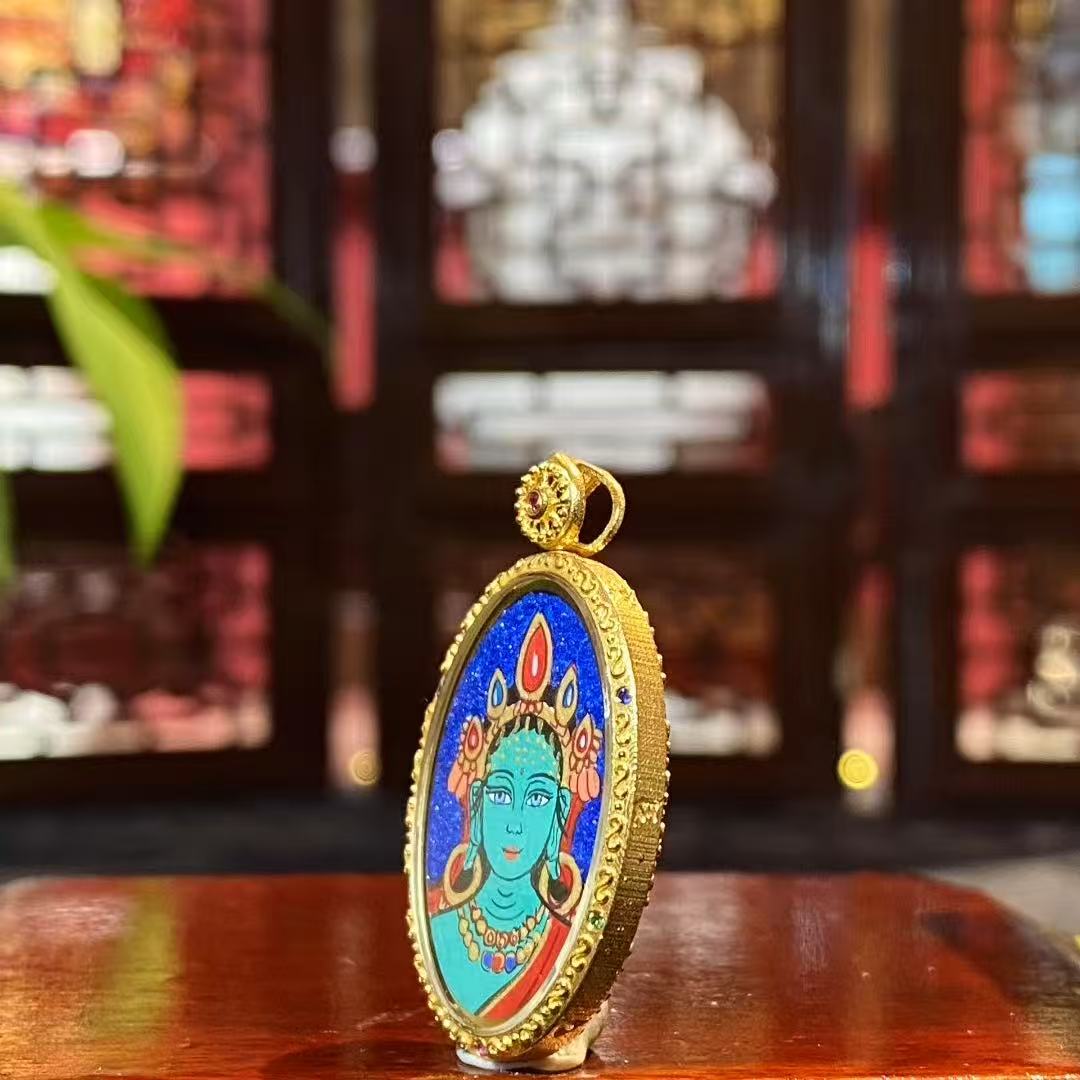 Side view of a double-sided Tibetan Thangka pendant set in an 18K gold Gau box with sapphire crystal, showing compact proportions and fine craftsmanship.
