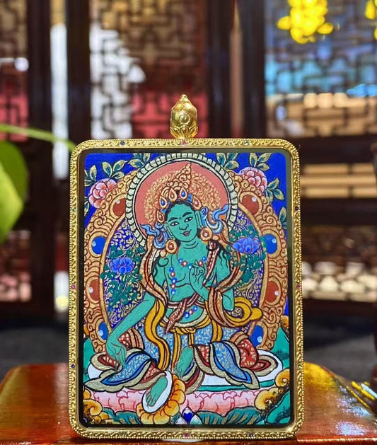Front view of a double-sided Green Tara Thangka pendant, hand-painted with 18K gold in Rebgong tradition, featuring Green Tara holding the utpala lotus in a compassionate posture.
