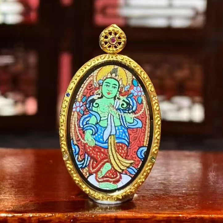 Front view of a double-sided Green Tara Thangka pendant, hand-painted with 18K gold in Rebgong tradition, depicting Green Tara as a symbol of compassion and wisdom.
