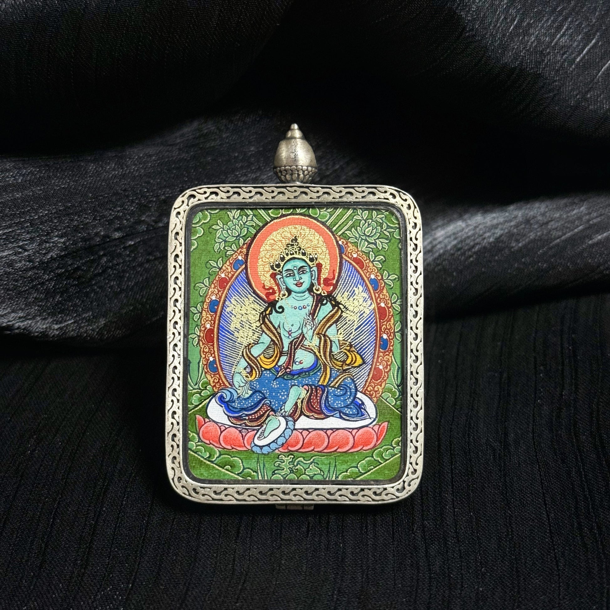 Front view of Green Tara mini thangka pendant highlighting traditional Tibetan thangka painting and ornate silver pendant frame