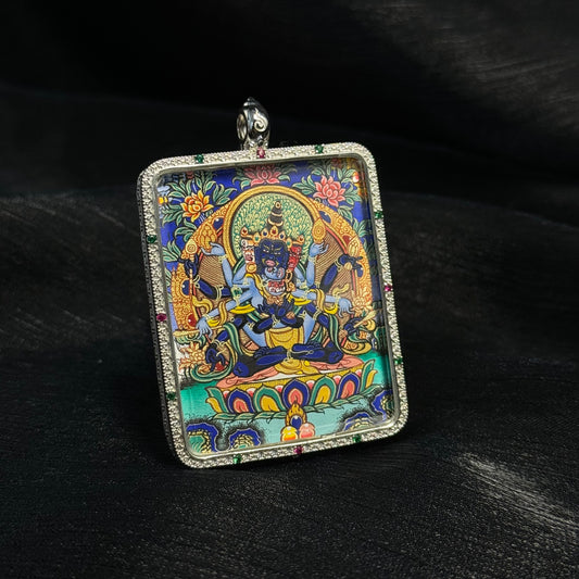 Angled view of Guhyasamaja Vajra miniature thangka pendant, Tibetan hand-painted artwork set in a sterling silver frame.