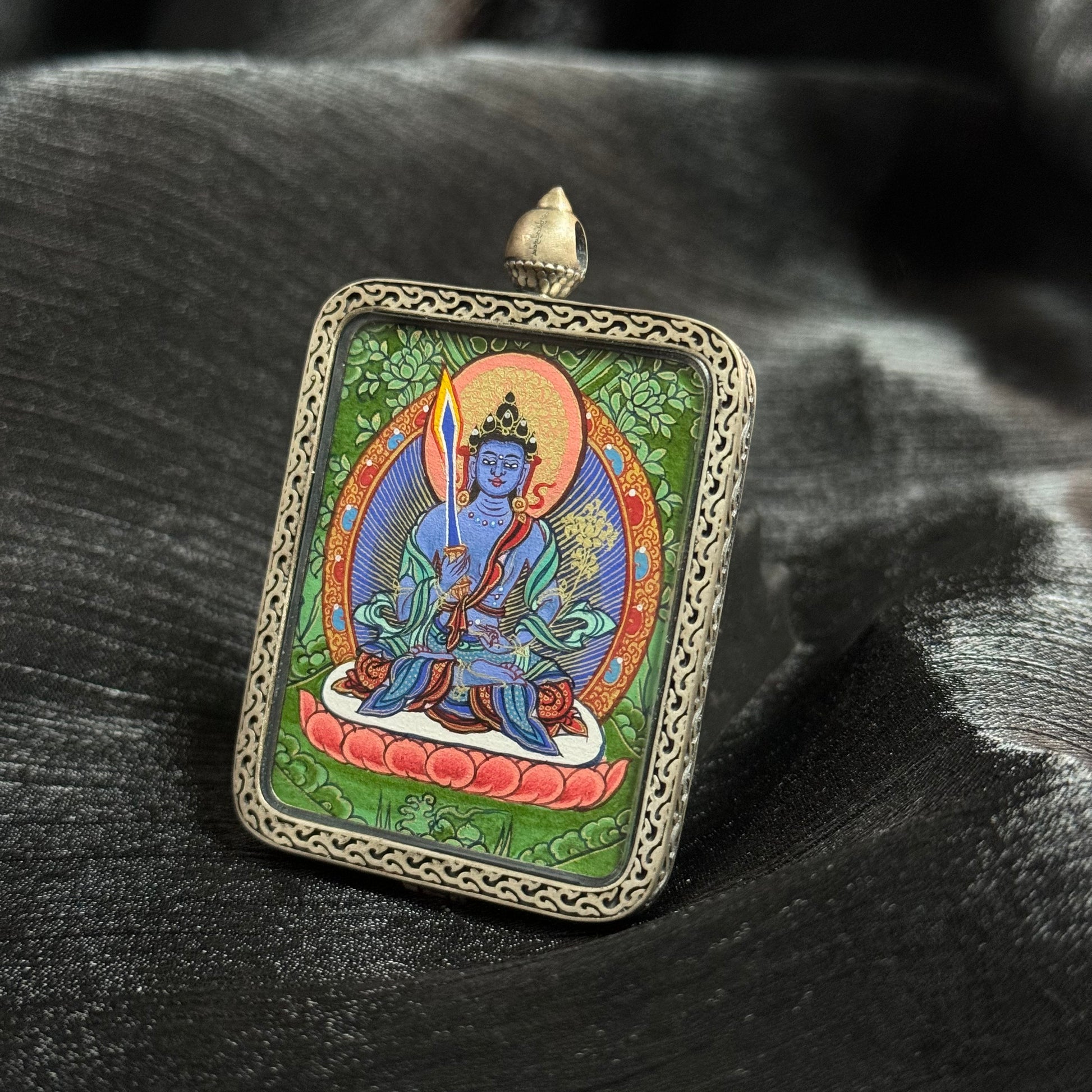 Close angled perspective of Akashagarbha Bodhisattva mini thangka pendant emphasizing precise linework, lotus throne detail and vibrant mineral pigment colors
