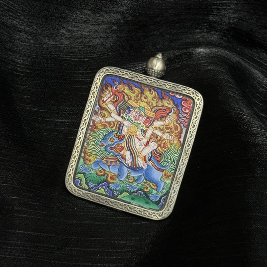 Close-up view of Baihar mini thangka pendant highlighting hand-painted details, vivid mineral pigments, and protective silver casing