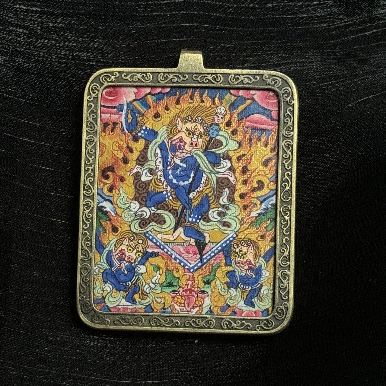 Front view of Simhamukha Dakini mini thangka pendant showing wrathful lion-faced dakini with flaming halo, detailed mineral pigment painting and engraved copper frame