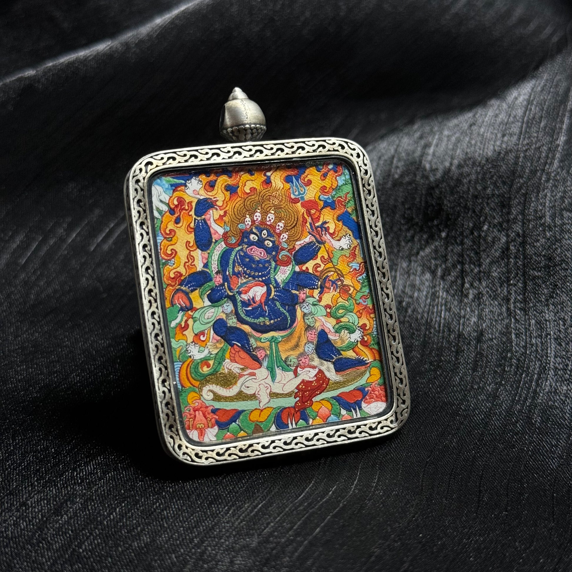 Close perspective of Six-Armed Mahakala mini thangka pendant emphasizing gold powder detailing, intricate linework and vibrant Tibetan protector deity composition