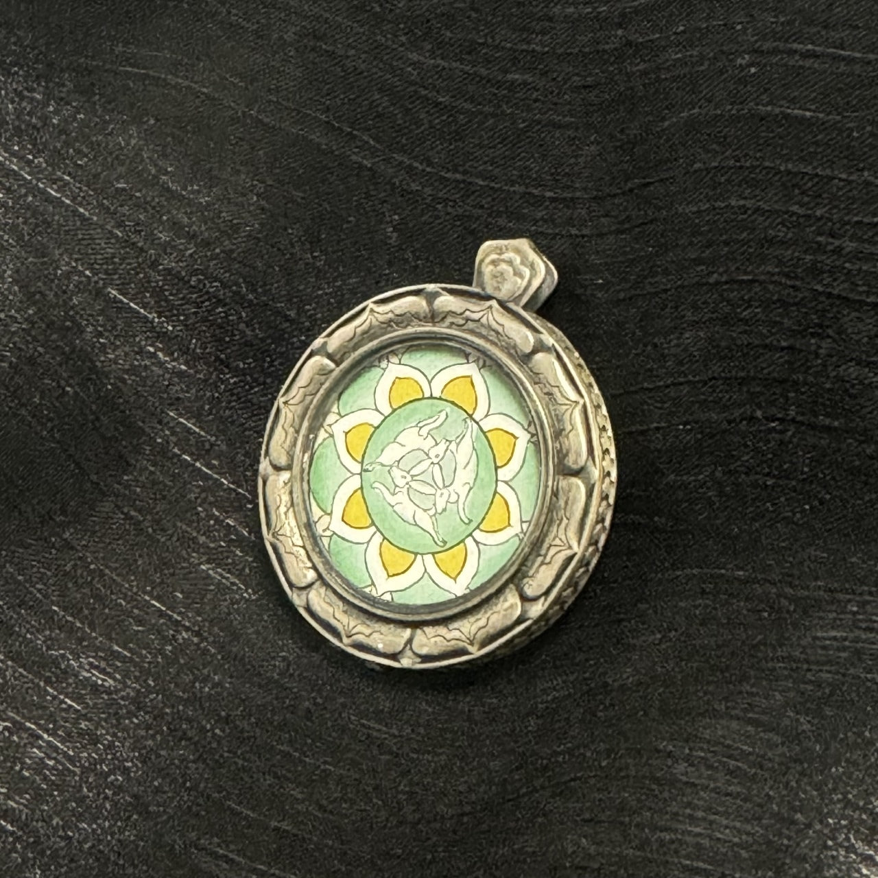 Close-up of hand-painted Three Hares with Shared Ears motif, fine outline lines, green layered mineral pigments, symmetrical lotus-style pattern