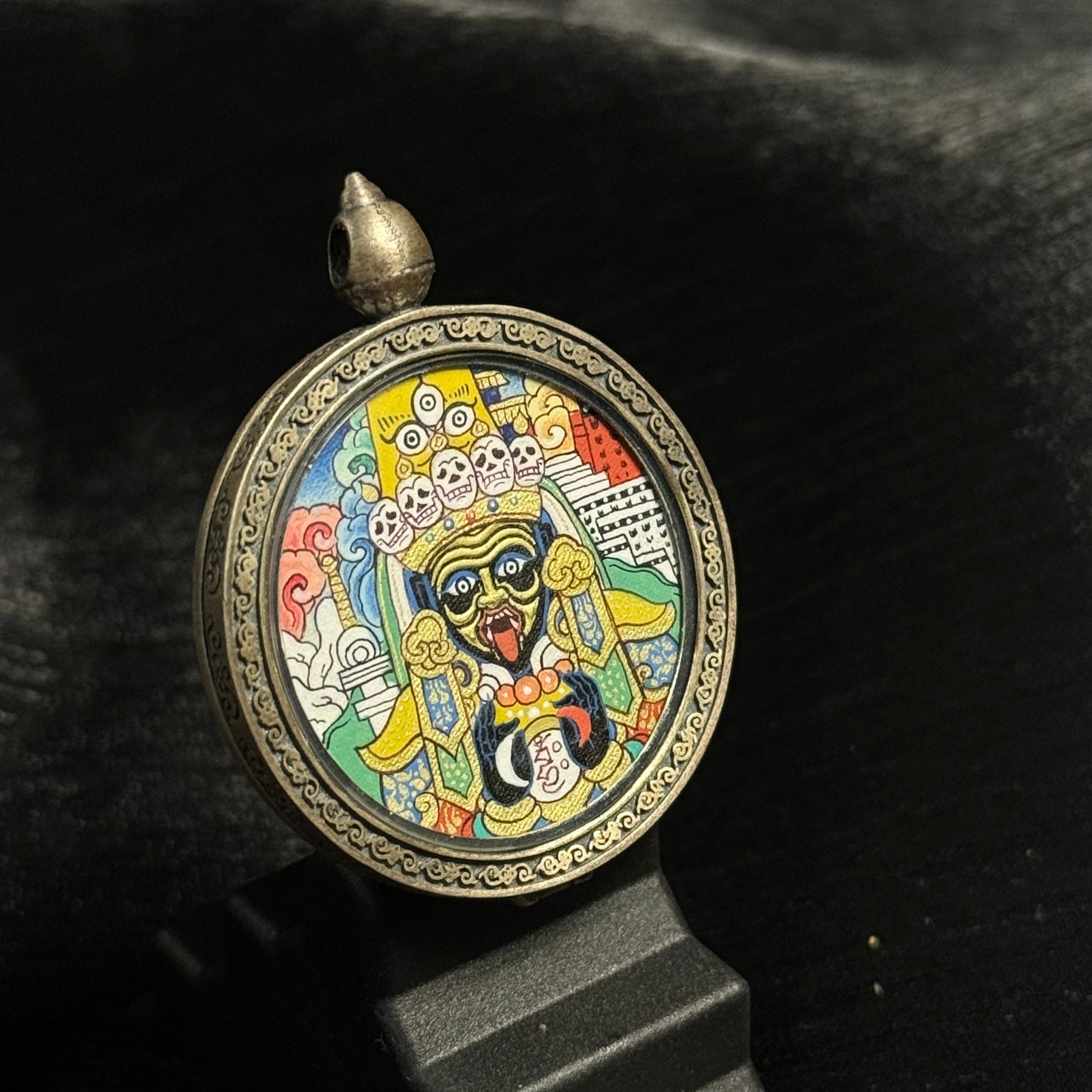Close angled view highlighting the facial features of Zaki Lhamo, layered mineral pigments, gold powder accents, and traditional Tibetan architectural background.