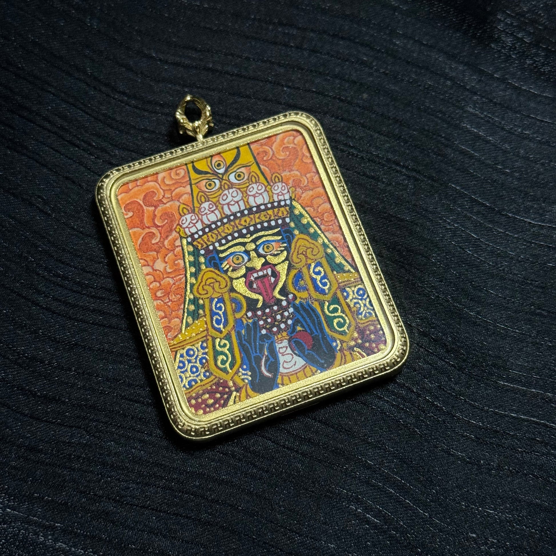 Close angled view of Zaki Ram thangka pendant highlighting vivid mineral pigment layers and traditional Nepalese Buddhist iconography