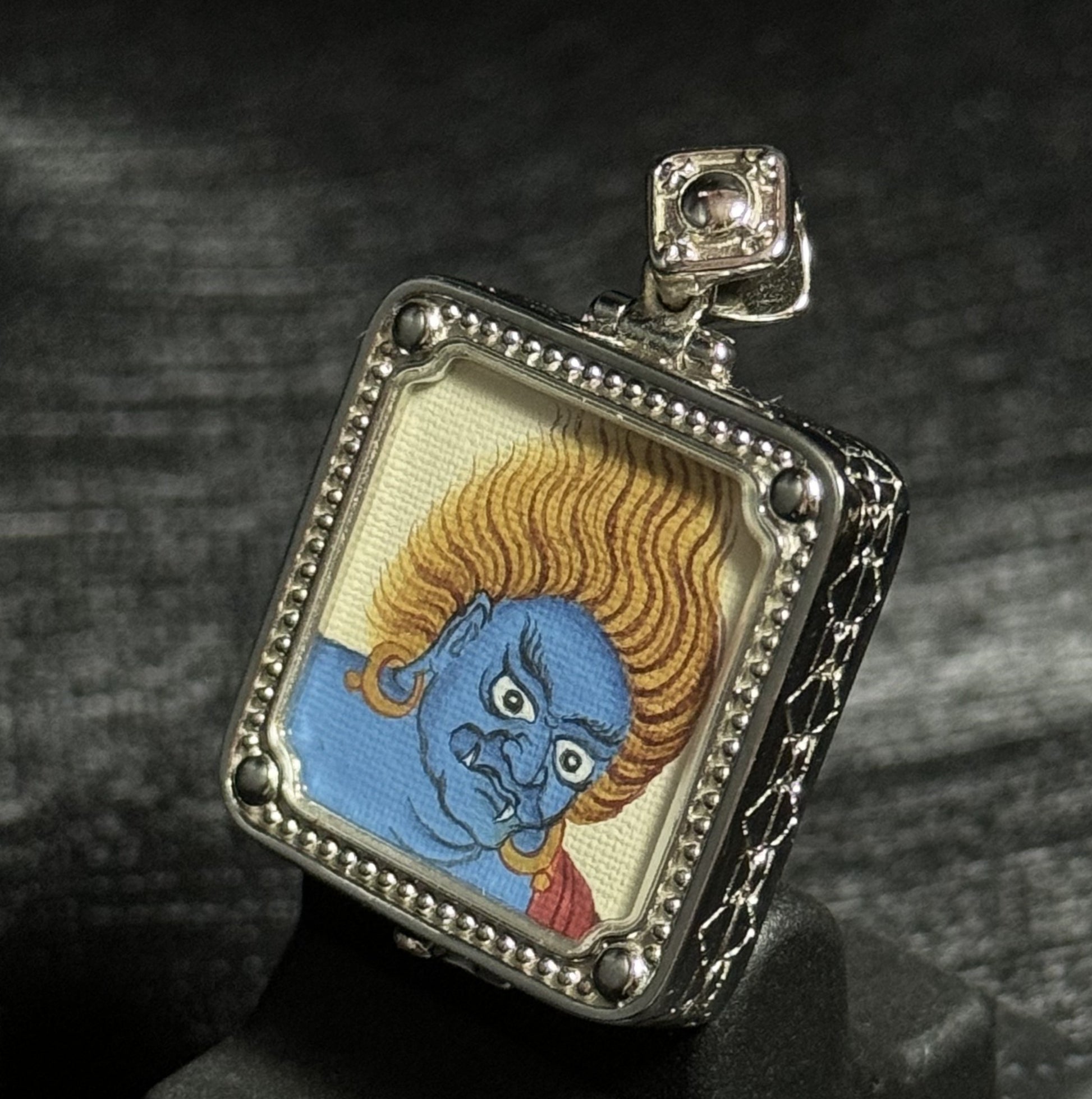 Hand painted Acalanatha Tibetan thangka pendant showing blue wrathful deity with flaming hair